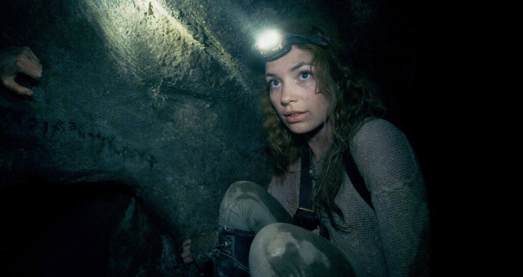 Scarlett (PERDITA WEEKS) traverses miles of twisting catacombs beneath the streets of Paris in As Above/So Below.